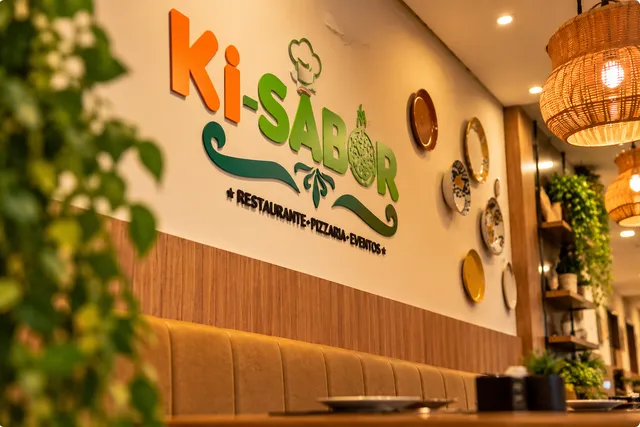 Logo do Ki-Sabor na parede do salão, com decoração e iluminação do ambiente